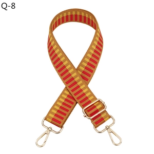Detail view of woven guitar style bag strap with gold metal hooks and adjustable buckle