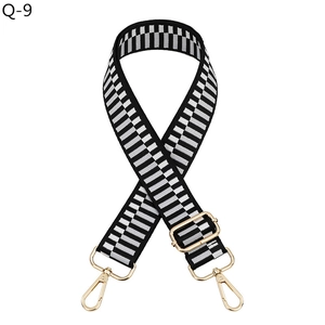 Macro shot of black and gray geometric woven strap with golden metal lobster clasps
