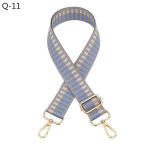 Detail view of woven geometric jacquard bag strap with gold metal lobster clasps