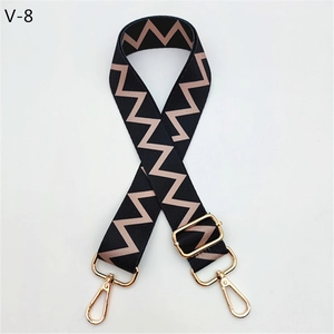 Detail of adjustable bag strap with black and brown zigzag pattern and gold metal hardware