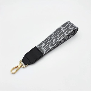 Leopard print handbag strap with black leather accents and gold metal snap hook