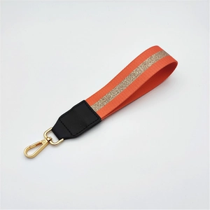 Orange woven handbag strap accessory with gold glitter detail and metal lobster clasp