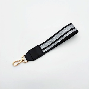 Detail of black woven strap with silver sequins and gold metal lobster clasp