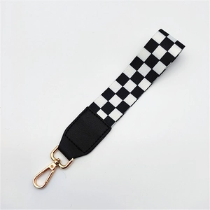 Black and white checkerboard handbag strap with gold metal lobster clasp and leather joint