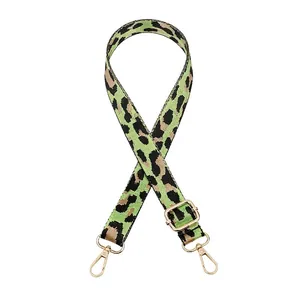 Gros plan sur la bandoulière réglable à motif léopard avec boucles en métal doré brillant