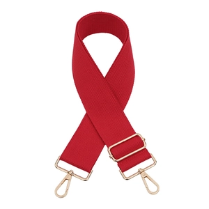 Detail view of red wide canvas bag strap with shiny gold swivel hooks and metal buckle