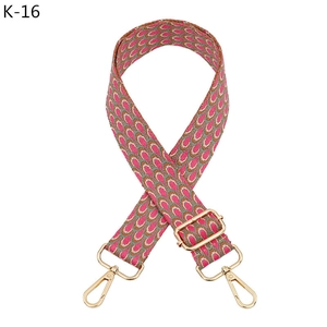 Close-up of adjustable pink and grey jacquard bag strap with gold metal hardware