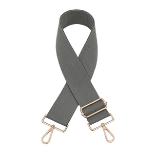 Detail of adjustable grey nylon bag strap with polished gold-tone lobster clasps and buckles