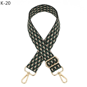 Close-up of adjustable woven shoulder strap with green peacock jacquard pattern and gold hooks
