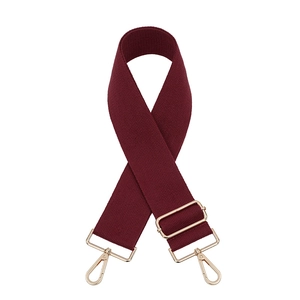Detail of burgundy wide woven shoulder strap with adjustable golden metal buckles