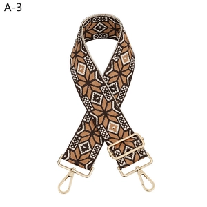 Detail of ethnic geometric woven bag strap with golden lobster clasps and adjustable buckle