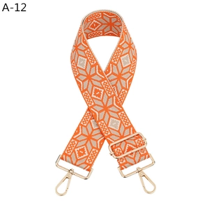 Close-up of ethnic geometric pattern strap with adjustable golden metal buckle and clasp