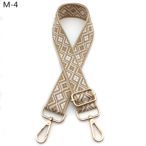 Detail eines verstellbaren geometrischen Jacquard-Gurts mit goldenen Karabinerhaken