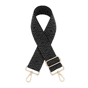 Close-up of adjustable woven bag strap with geometric patterns and gold metal buckles