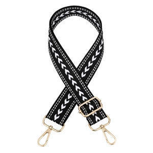 Detail of adjustable black woven strap with white arrow pattern and gold metal hardware