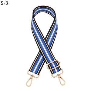 Detail of adjustable striped bag strap with gold lobster clasps and metal buckle
