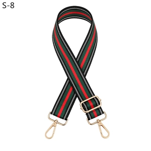 Detail of adjustable striped canvas shoulder strap with golden metal lobster clasps