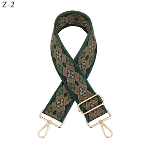 Detail of adjustable woven diamond pattern strap with gold metal hooks and dark green finish