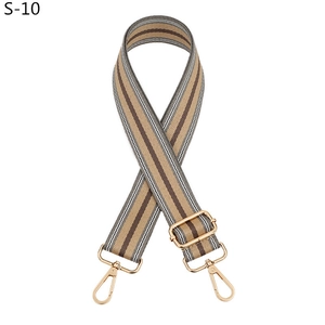 Macro shot of striped replacement bag strap with golden metal swivel hooks and buckles
