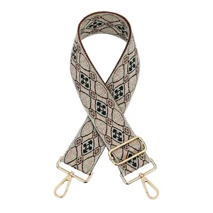 Close-up of diamond pattern wide purse strap with golden metal lobster clasps