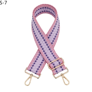 Détail d'une bandoulière tissée avec motif à losanges violets et crochets en métal doré