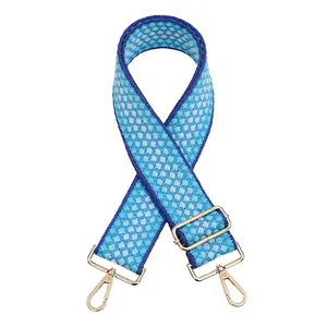 Détail de la bandoulière tissée géométrique bleu et blanc avec attaches dorées