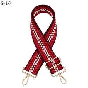 Détail de la bandoulière tissée géométrique rouge et blanche avec fermoirs dorés