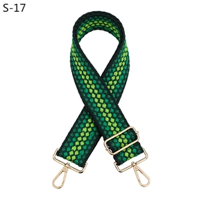 Détail de la bandoulière tissée à damier vert avec mousquetons en métal doré