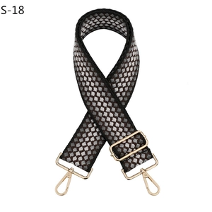 Vue détaillée d'une large bandoulière tissée avec motif alvéolé noir et blanc et boucle