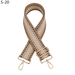 Détail d'une large bandoulière réglable avec motif géométrique kaki et boucles dorées