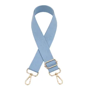 Dettaglio tracolla larga intrecciata azzurro chiaro con moschettoni in metallo dorato regolabili