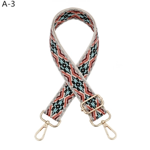 Detail of adjustable woven canvas strap with ethnic geometric patterns and gold hardware