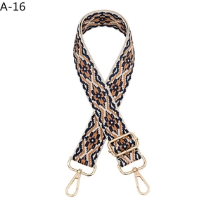 Close-up of ethnic geometric jacquard bag strap with golden metal lobster clasps