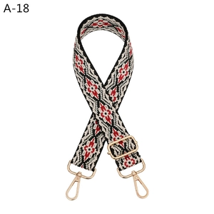 Close-up of ethnic geometric pattern woven bag strap with light gold metal lobster clasps
