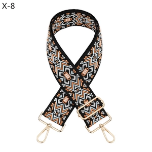 Detailaufnahme des breiten Taschenriemens mit Ethno-Muster und Goldkarabinern