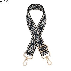 Close-up of geometric ethnic pattern bag strap with gold lobster clasps and slider