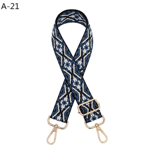 Detail of blue and white ethnic woven bag strap with golden metal swivel hooks