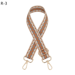 Detail view of adjustable geometric orange and grey bag strap with gold lobster clasps