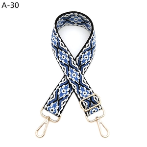 Detail of adjustable geometric ethnic style woven strap with light gold metal spring hooks
