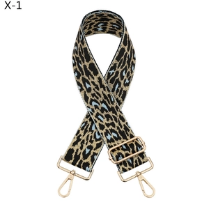 Detail of adjustable leopard print bag strap with golden metal hooks and blue accents