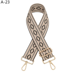 Détail d'une bandoulière réglable à motif losanges avec des fermoirs dorés