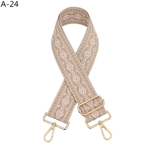 Gros plan sur la bandoulière en jacquard rose et beige avec mousquetons dorés