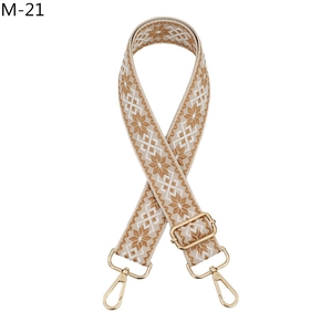 Close-up of bohemian woven shoulder strap with geometric patterns and gold metal clasps
