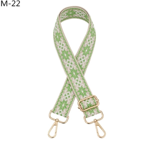 Detail of adjustable geometric ethnic woven bag strap with golden metal hardware