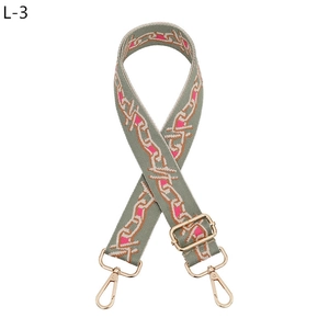Close-up of adjustable woven strap with geometric chain patterns and gold metal hardware