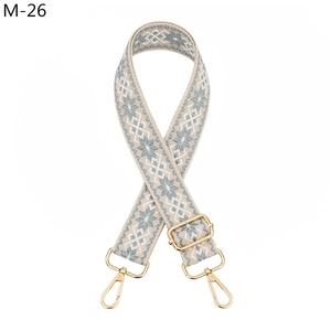 Detail of adjustable woven purse strap with geometric pattern and gold swivel hooks