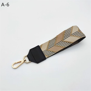 Detail of the wide woven strap with geometric pattern and gold swivel snap hooks