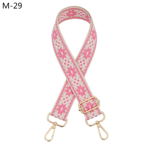 Detail of pink bohemian woven bag strap with golden metal lobster clasps and buckle