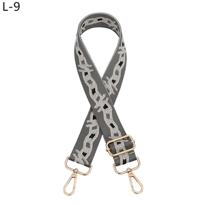 Detail of adjustable gray woven strap with beige chain pattern and gold lobster clasp
