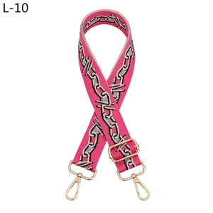 Close-up of adjustable pink geometric embroidery shoulder strap with gold metal hooks
